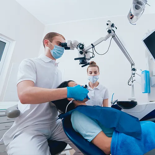 patient in dental chair receiving treatment from dentist