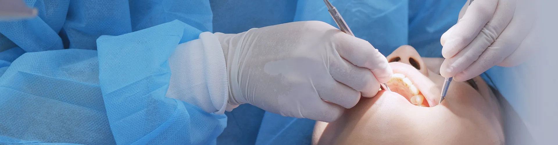 gloved hands using dental tools in person's mouth