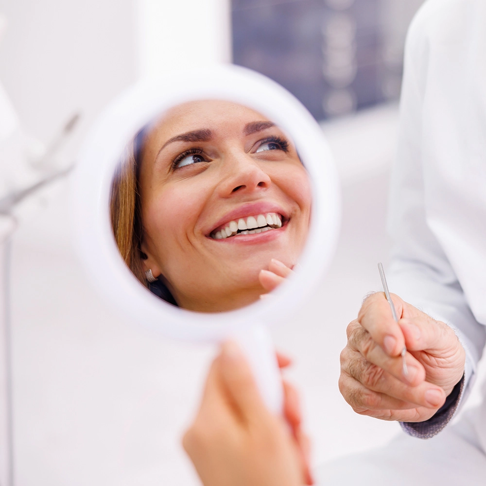 Patient smiling in the mirror