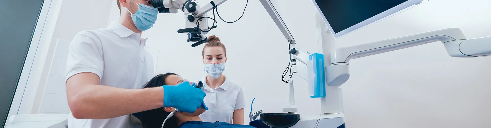 patient in dental chair receiving treatment from dentist