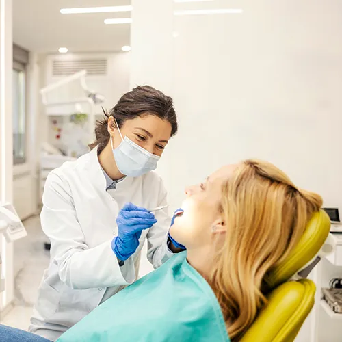 Dentist using dental tools in patient's mouth.