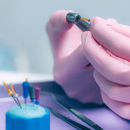 gloved hands holding dental tools